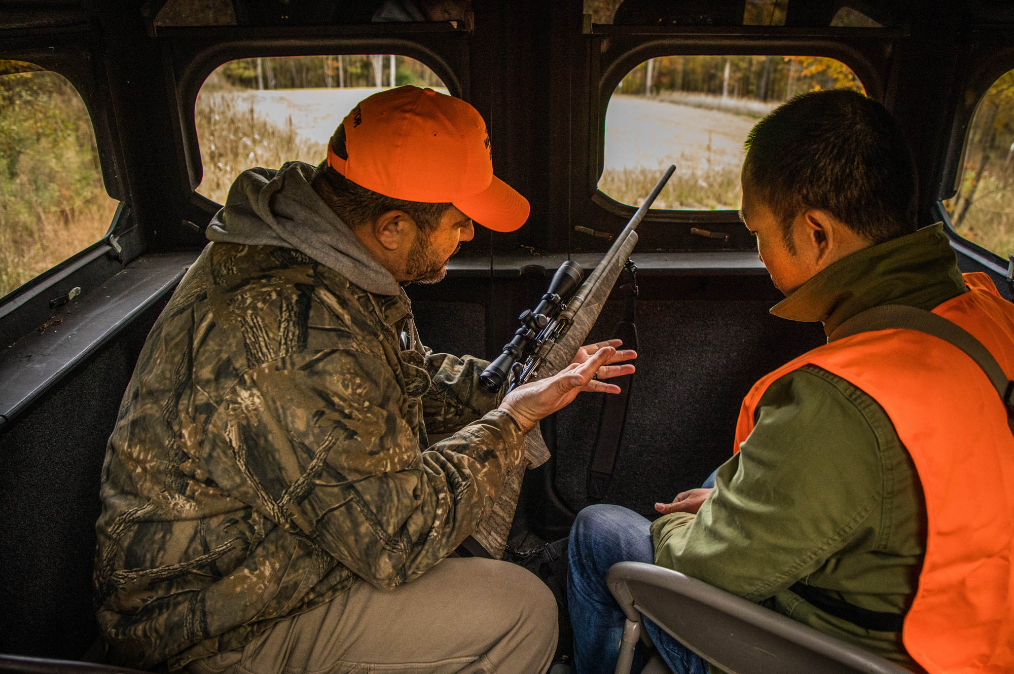 mentor showing a new hunter how to use a rifle