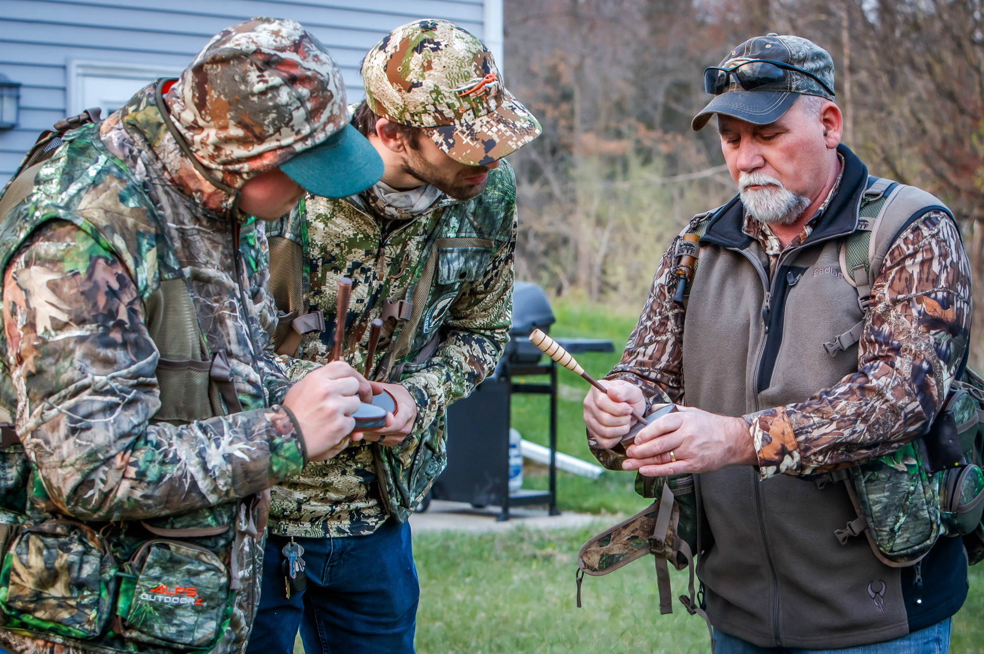 turkey hunter showing two new hunters how to use a turkey call