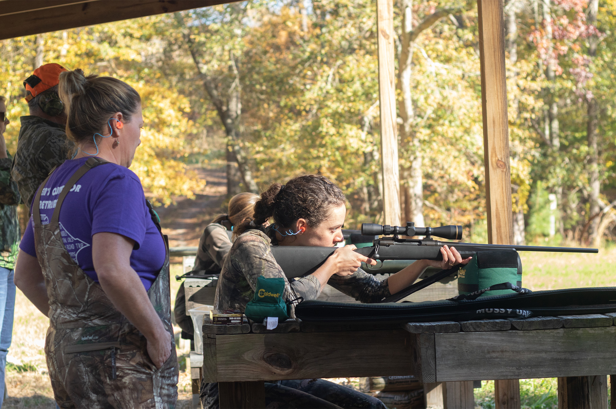 Instructor teaching new hunter how to shoot at range.