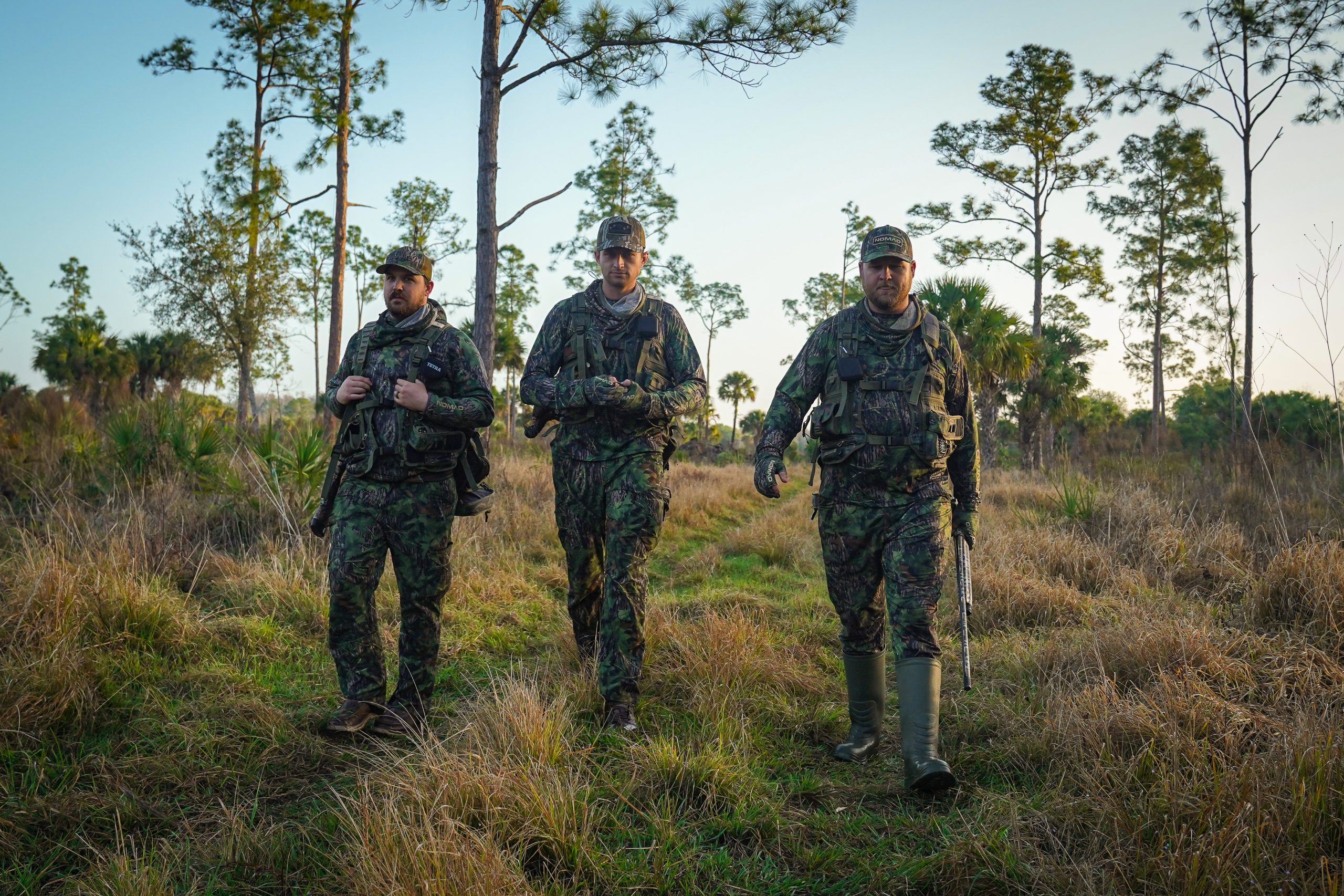 three hunters walk side by side