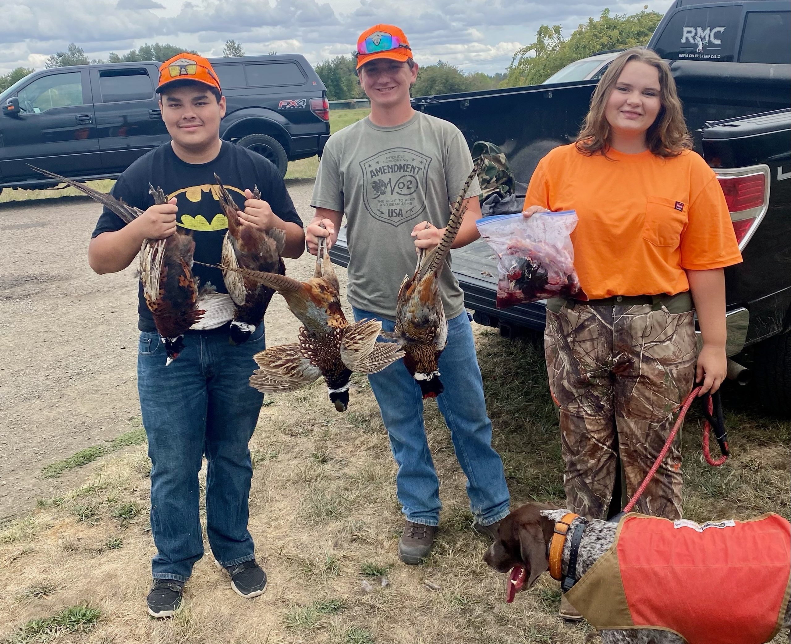 Three children standing with their harvested birds.