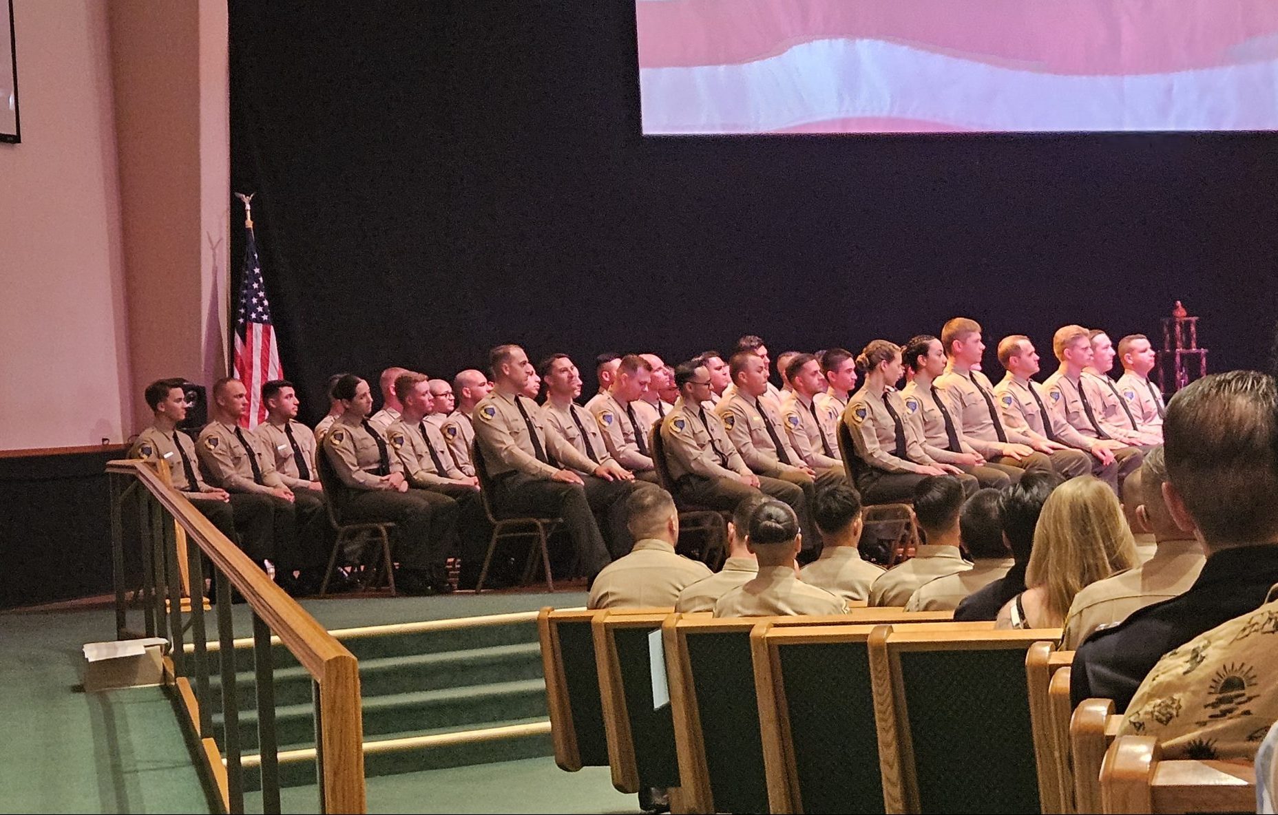 All game warden graduates sitting onstage