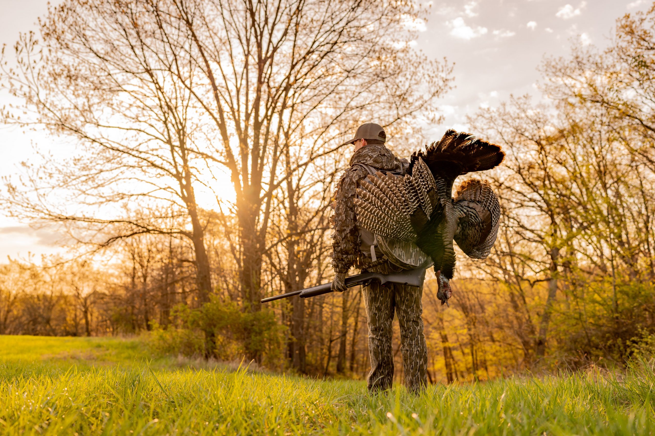 hunter with a bird walking across a field