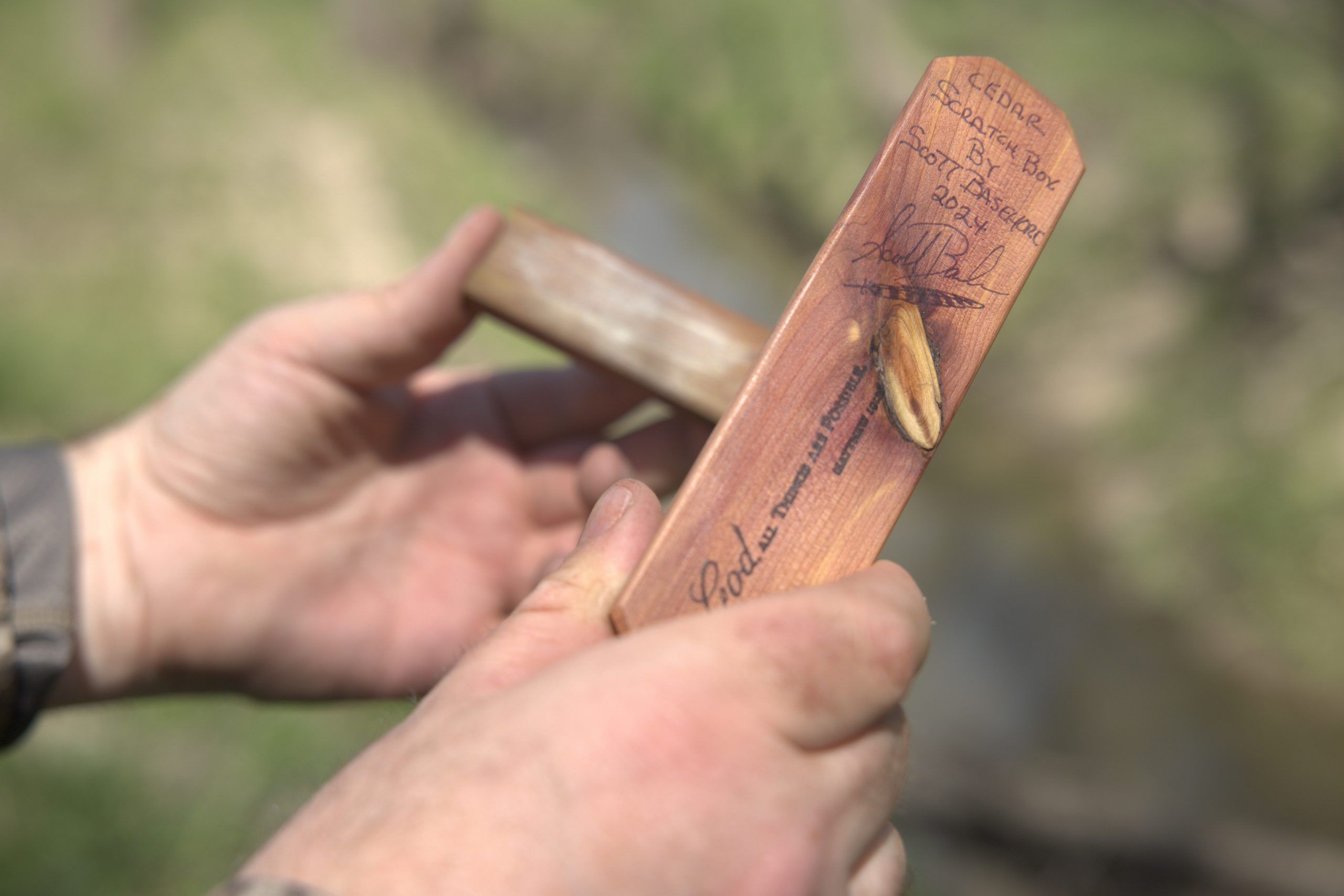 hands holding a scratch box turkey call